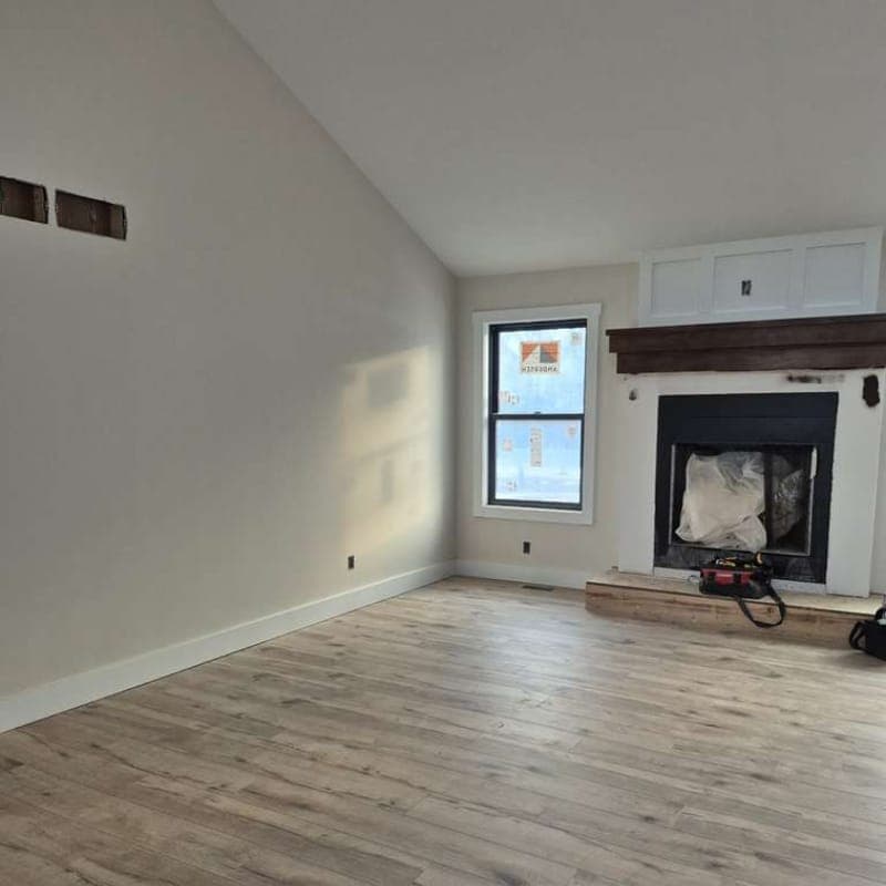 Wide-plank flooring in an open living room with fireplace