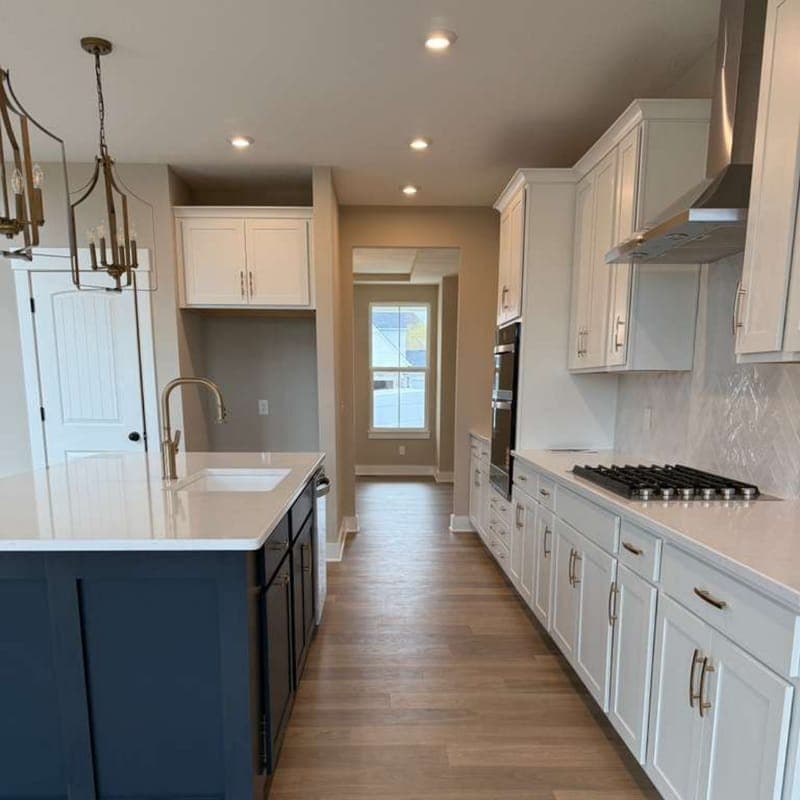 Kitchen with a navy island and new plank flooring