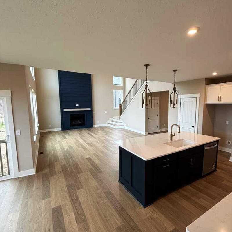 Open-plan living area with navy fireplace wall and new flooring
