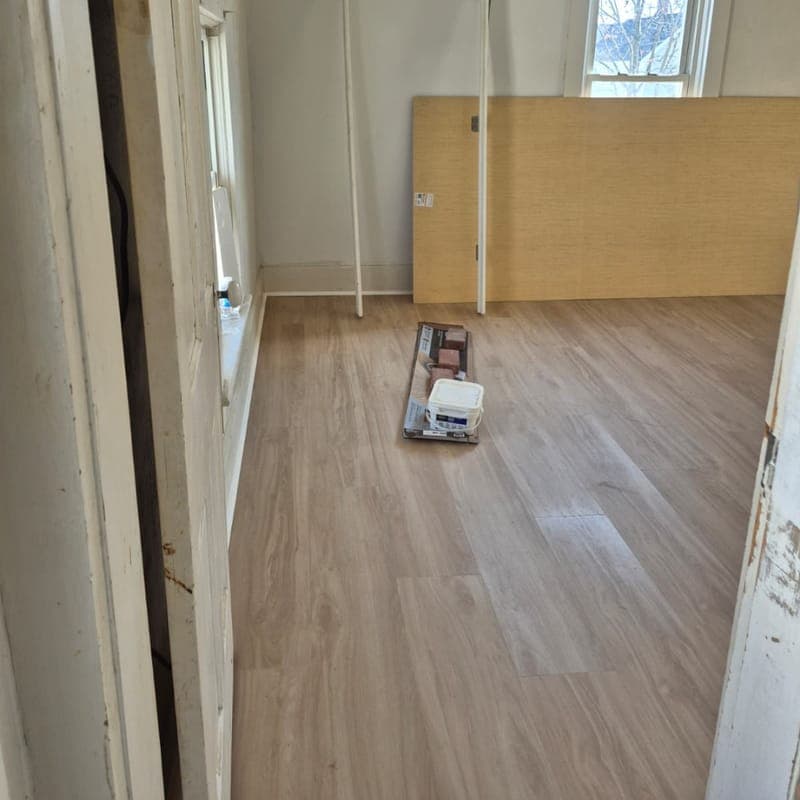 Room with new plank flooring while finishing work is still under way