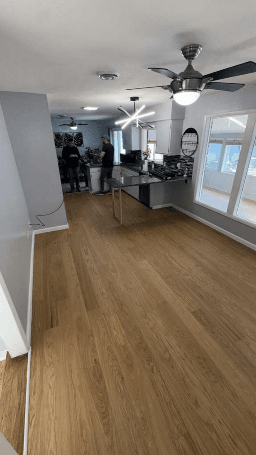 Open living and kitchen area with newly installed wood-look plank flooring